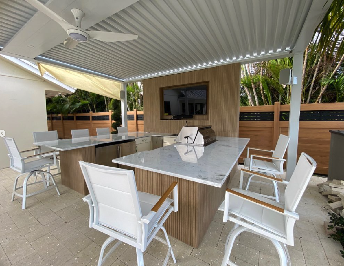 Outdoor kitchen with marble island and TV
