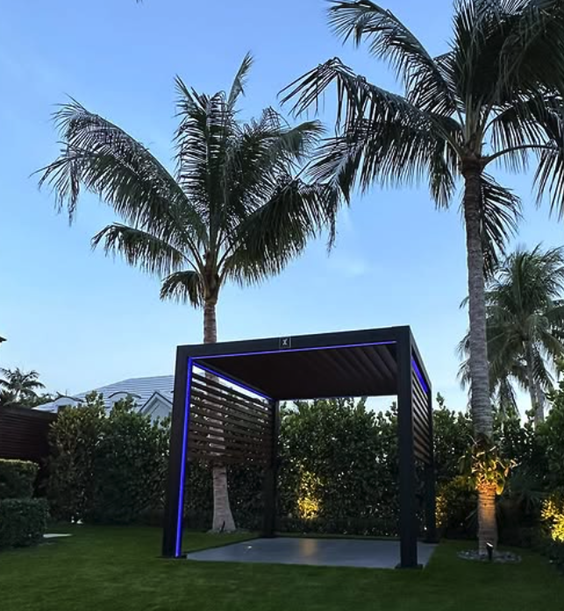 Motorized louvered pergola with integrated LED lighting at night