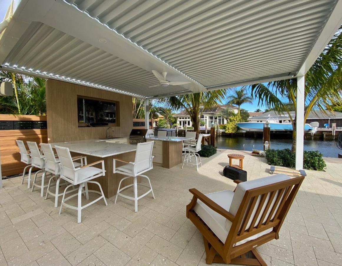 Waterfront outdoor kitchen with pergola cover, marble island, and Intracoastal view